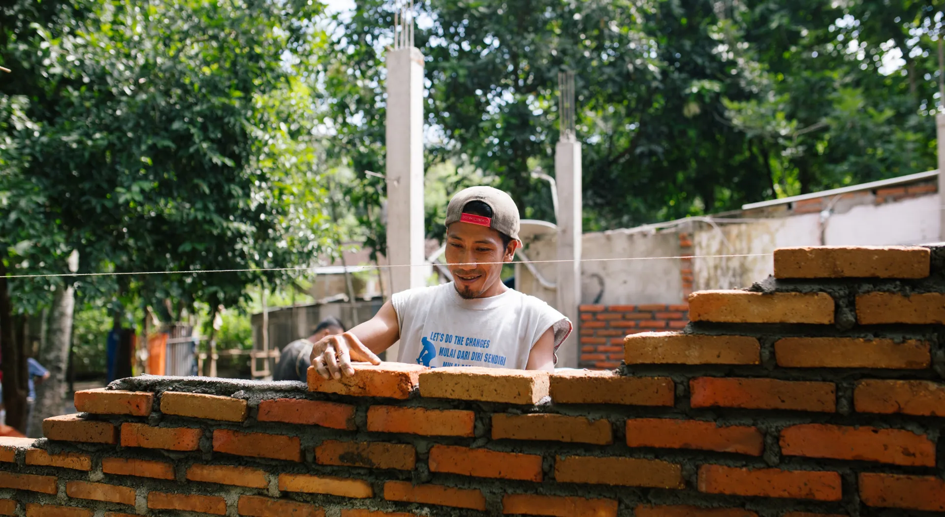 Mann baut ein Haus in Indonesien