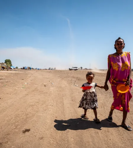 Flüchtlingslager im Sudan: Frau hält ihr Kind an der Hand