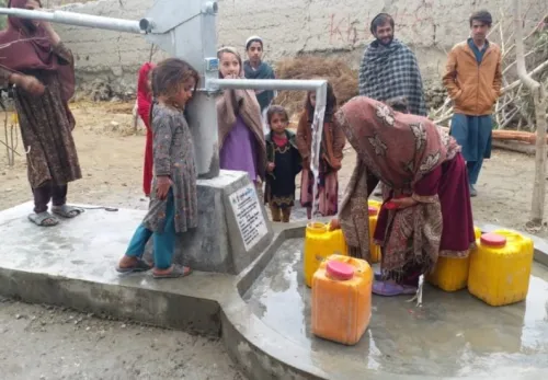 Menchen schöpfen Wassern an einer Wasserpumpe in Afghanistan