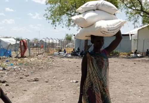 A woman in South Sudan carrying food bags on her head